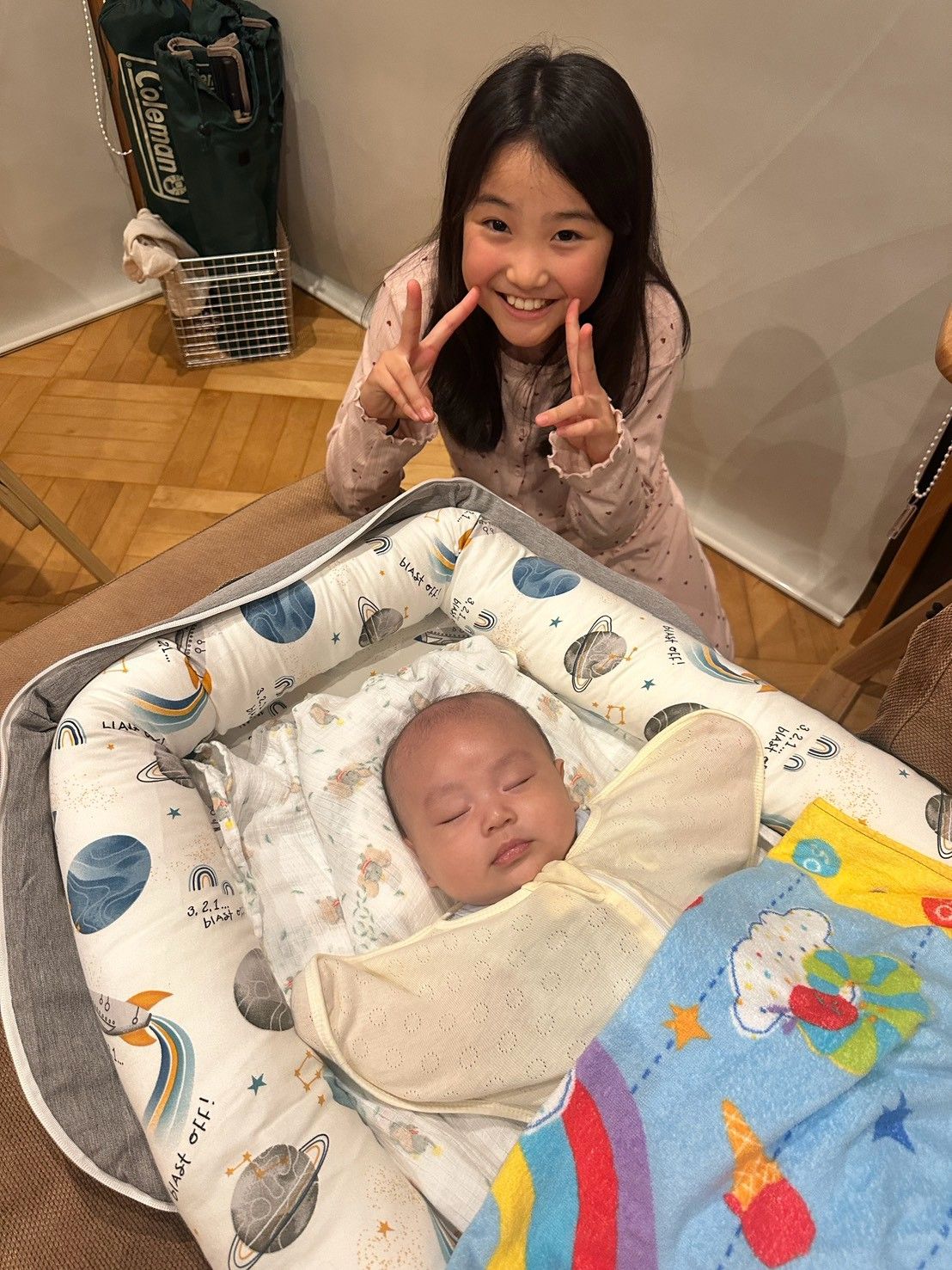 赤ちゃんの隣でピースサイン