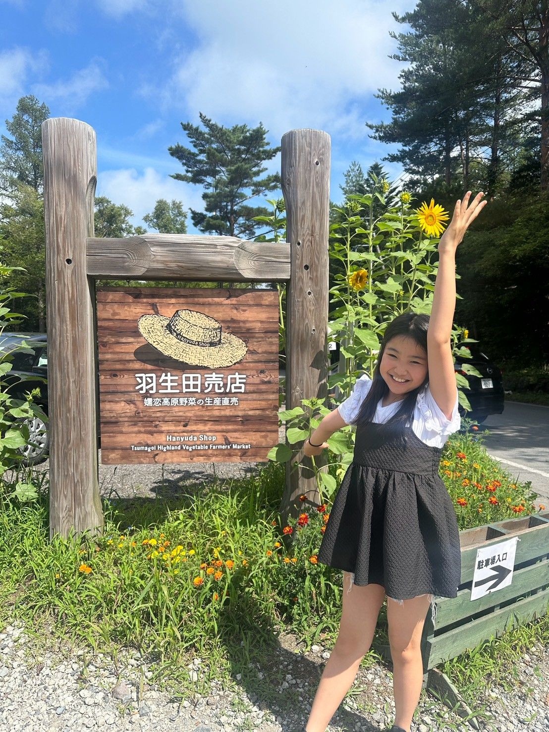 お店の看板の前で